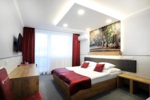 a bedroom with a bed and a painting on the wall at Hotel Strážnice in Strážnice +95 photos