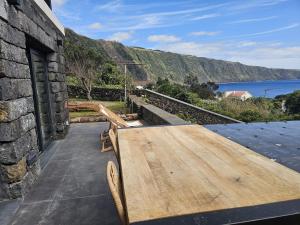 a wooden table on a patio with a view of the water at Blue Horizon Apartments in Varadouro
