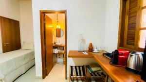 a room with a desk and a bedroom with a bed at Vila Bonita Guest House in Alto Paraíso de Goiás