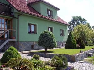a green house with a garden in front of it at Apartmán Vysočina in Zvole