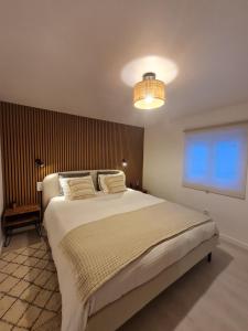 a bedroom with a large white bed with a light at Alba Odeceixe - casa aurea in Odeceixe
