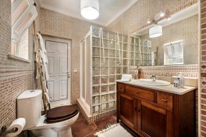 a bathroom with a toilet and a sink and a mirror at Family & Friends Retreat w/ Pool - Moncarapacho in Tavira