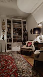 a living room with a couch and a chair and bookcases at SOLO ! Charme Boutique in Avis