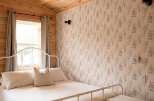 a bedroom with a white bed with a window at Lawrencetown Lodge - The Pine 2 Bed Room in Three Fathom Harbour