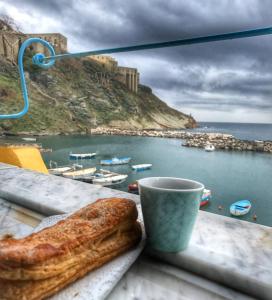 een kopje koffie en een bagel op een tafel met uitzicht bij La Casa di Titina in Procida