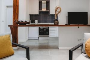 a kitchen with a desk with a tv on it at Artist’s corner in central Caldas in Caldas da Rainha