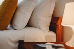a close up of a bed with white pillows at Artist’s corner in central Caldas in Caldas da Rainha