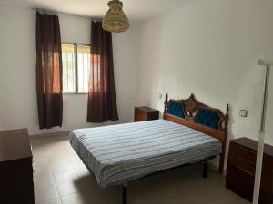 a bedroom with a bed with blue pillows on it at Casa familiar La Cabra in Talavera de la Reina