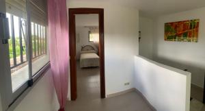 a hallway with a room with a bed and a window at Casa familiar La Cabra in Talavera de la Reina