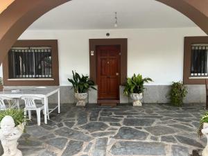 a patio with a table and a wooden door at Casa familiar La Cabra in Talavera de la Reina