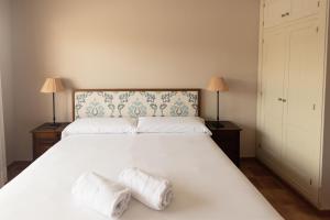 a bedroom with a large white bed with two pillows at Siete Villas Olivencia Natural in Agua Amarga +42 photos