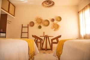 a room with two beds and a table and chairs at Hotel Aldea Katún in Izamal