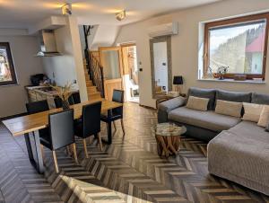 a living room with a couch and a table at MY TIME BLED Holiday House with sauna in Zgornje Gorje