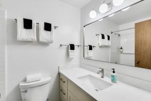 a white bathroom with a sink and a mirror at Cozy Hilltop Seattle Stay with Yard & Parking in Seattle +19 photos