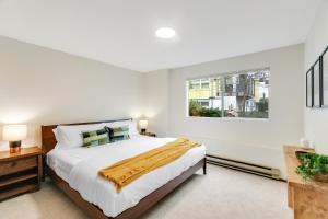 a white bedroom with a large bed and a window at Cozy Hilltop Seattle Stay with Yard & Parking in Seattle