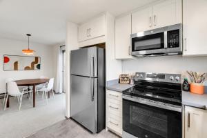 a kitchen with a stainless steel refrigerator and a table at Cozy Hilltop Seattle Stay with Yard & Parking in Seattle