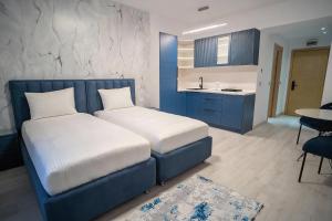 a bedroom with two beds and a kitchen with a sink at LaRin Residence in Bucharest