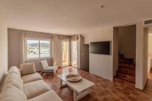 a living room with a couch and a table at Siete Villas Olivencia Natural in Agua Amarga