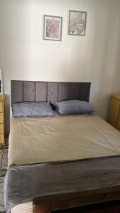 a bed with a headboard in a bedroom at Pousada Rensule in Bertioga