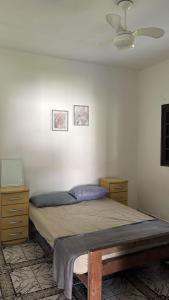 a bedroom with a bed and a ceiling fan at Pousada Rensule in Bertioga
