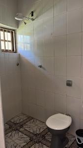 a bathroom with a toilet and a shower at Pousada Rensule in Bertioga