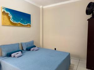 a bedroom with two blue beds and a painting on the wall at Apartamento Central in Passos