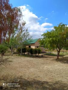a building with a green roof in a park at Cabaña La Escondida in Villa de la Quebrada