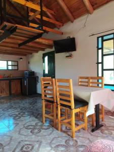 a kitchen and dining room with a table and chairs at Cabaña La Escondida in Villa de la Quebrada +6 photos