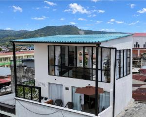 a balcony of a house with windows and mountains in the background at Apartamentos FM 401 in Líbano