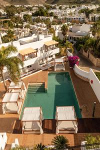 an overhead view of a swimming pool with chairs and a building at Siete Villas Olivencia Natural in Agua Amarga