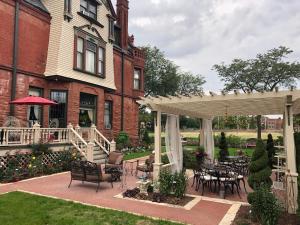 a patio with tables and chairs in front of a house at Schuster Mansion Bed & Breakfast in Milwaukee