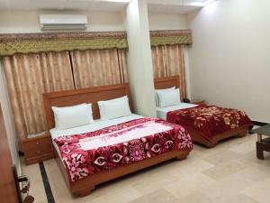a bedroom with two beds in a room at Sunrise BnB in Karachi