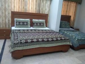 two beds in a room with twoituresitures at Sunrise BnB in Karachi +9 photos