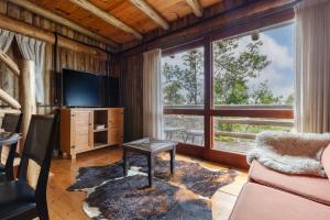 a living room with a tv and a large window at Pousada Parador 33 in Biguaçu
