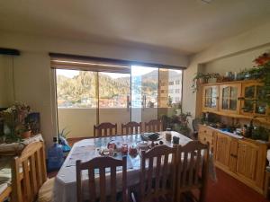 una sala da pranzo con tavolo e sedie e una finestra di Olimpo a La Paz