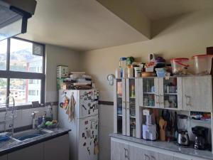 una cucina con un frigorifero con molti magneti sopra di Olimpo a La Paz 1 altra foto