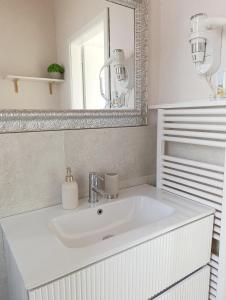 a bathroom with a white sink and a mirror at Kasakiwi Apartment in Vicenza +11 photos