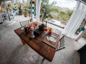 a wooden table with food on it in a room with windows at hotel boutique Almaia 17 cerca del aeropuerto jose m cordova in Rionegro