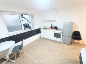 a kitchen with a sink and a table and chairs at Deluxe Studio-Apartments in Mörfelden-Walldorf +15 photos