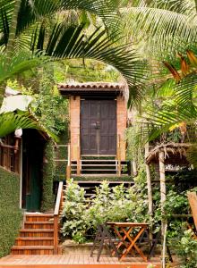 una casa con una puerta negra y una mesa de madera en Pousada Afrika en Búzios