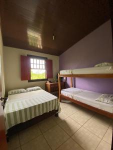 a bedroom with two bunk beds and a window at Casa Ypê in Pirenópolis