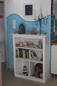 ein weißes Bücherregal mit zwei Kerzen oben drauf in der Unterkunft Teresa Spiti in Adamas