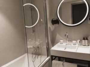 a bathroom with a shower and a sink and a mirror at Mercure Paris 17 Batignolles in Paris