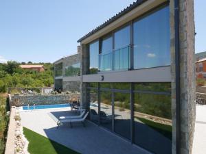 ein Haus mit Blick auf eine Terrasse und einen Pool in der Unterkunft Villa Paradise in Vrbnik