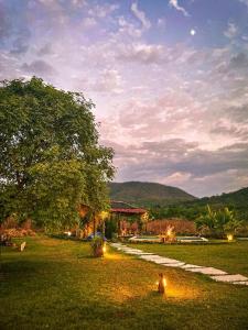 a park with lights in the grass with a building at Casa Ypê in Pirenópolis