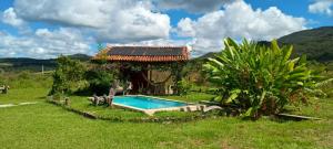 a small house with a swimming pool in the yard at Casa Ypê in Pirenópolis