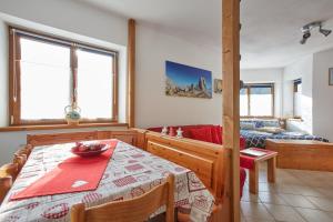 a dining room with a table and a couch at Dolomiti Comfortspace Free Parking in San Niccolò Comèlico