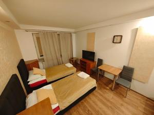 a room with three beds and a desk and a television at Vistula Home in Płock