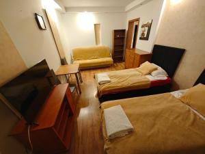 a room with three beds and a flat screen tv at Vistula Home in Płock