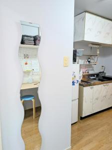 a kitchen with a white refrigerator and a table at エルビスコート井尻101号 in Morooka
